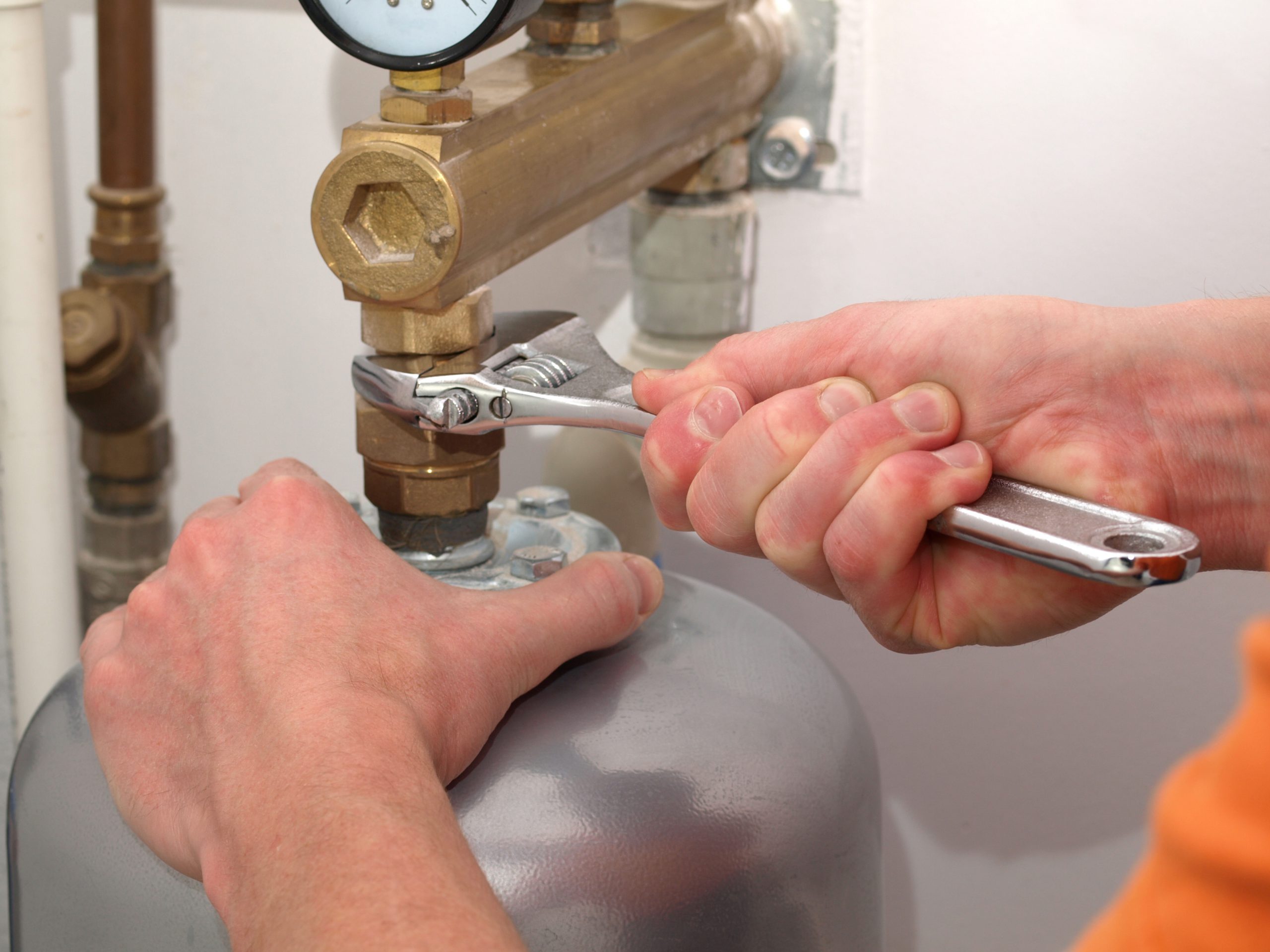 Photo of a person fixing a pipe fitting